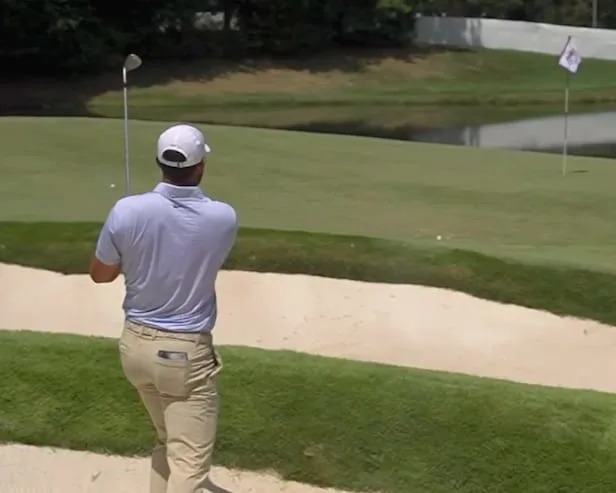 Watch Scottie Scheffler’s bunker shot bounce off a sprinkler and roll into the water - Yahoo Sports
